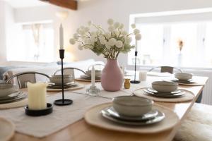 a dining room table with a vase of flowers and candles at The Barn, Chipping Norton, Cotswolds in Chipping Norton