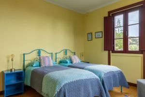 two beds in a bedroom with yellow walls at Casa do Cerco in Água de Pau +75 photos