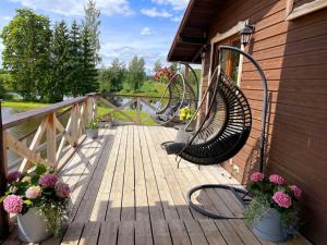 two benches sitting on a wooden deck with flowers at Brīvdienu māja Straumēni in Pāle +18 photos
