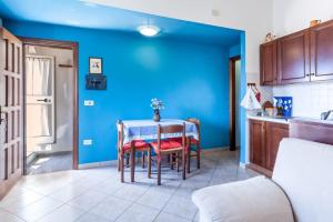 a kitchen with a table with chairs and a blue wall at Casa di campagna, Assisi in Sterpeto