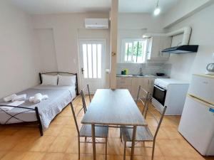 a room with a bed and a table and a kitchen at ESTIA Holiday Apartment & Studio in Vathi