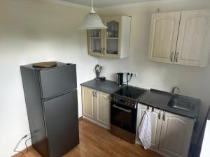 a kitchen with a black refrigerator and a sink at Mammaste Apartment in Mammaste