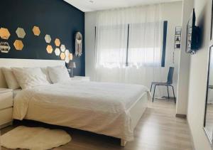 Un dormitorio con una cama blanca y una pared azul. en Bel Appartement Cosy dans le centre de Casablanca, en Casablanca