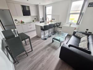 una sala de estar con un sofá y una mesa en Modern 4 BR flat with 4 ensuites in central Reading, en Reading