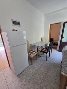 a kitchen with a white refrigerator and a table at Villa Kralj Mljet in Saplunara