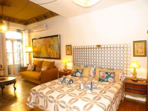 ein Schlafzimmer mit einem großen Bett und einer Couch in der Unterkunft Boutique Carthago Modernista Experiencias CarthagoTematizadas in Cartagena