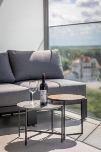 a bottle of wine sitting on a table next to a couch at Côte de la Mer, Ultra Luxurious, Sea View, use of shared pool and sauna in Cadzand