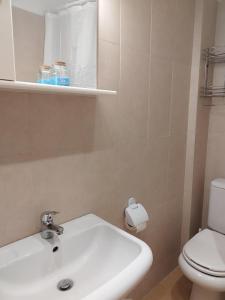 a bathroom with a white sink and a toilet at Artan`s garden house in Kalyves Poligirou +21 photos