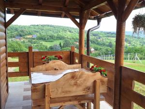 a wooden porch with a table and a view at Brvnara Beni in Vrdnik