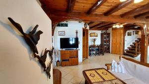 a living room with a tv and a table at Three Hearts in Áyios Pétros
