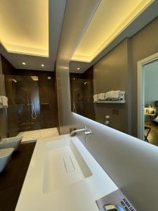 a bathroom with a sink and a large mirror at Delle Nazioni Milan Hotel in Milan