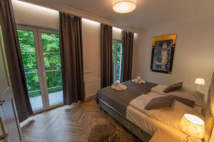 a bedroom with a large bed and large windows at Apartament Villa44 Świnoujście in Świnoujście