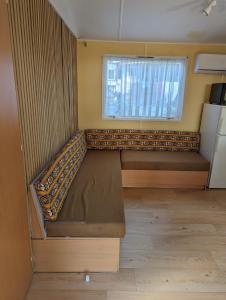 ル・カステレにあるMobilhome tout confort dans domaine boiséのベッドと窓のある小さな部屋