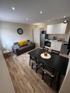 sala de estar con mesa negra y cocina en maison de la marine, en Dives-sur-Mer