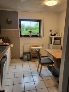 une petite cuisine avec une table et une fenêtre dans l'établissement Ferienwohnung Mosel Hunsrück, à Moritzheim
