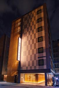 Un edificio con un diseño de tablero de ajedrez en el costado. en Sotetsu Fresa Inn Kyoto-Hachijoguchi, en Kioto