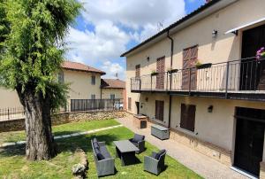 een park met bankjes en een boom naast een gebouw bij Monferrato AgriCottage Valentina in Calliano