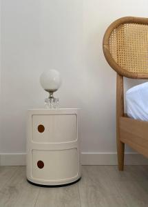 a white nightstand with a glass vase on it next to a bed at Blisko me in Wieprz