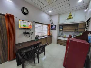una cucina e una sala da pranzo con tavolo e sedie di Venus Home Stay near IIM Indore a Indore Altre 2 foto