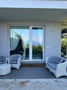 two chairs sitting in front of a large window at Suite Rose on the lake Arona in Meina