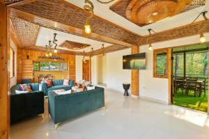 a living room with a couch and a table at WoodVista Cottages By Jomotel in Shimla