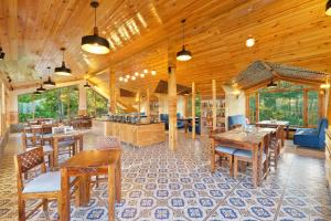 a large room with wooden ceilings and wooden tables and chairs at WoodVista Cottages By Jomotel in Shimla