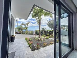 een open deur naar een patio met een palmboom bij Gertrudes Dream House in Ponta do Sol