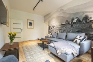 un soggiorno con un divano e un quadro sul muro di Apartamenty Krupówki 4 a Zakopane