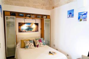 a small bedroom with a bed with white sheets and pillows at Dimora Le Vele - ELEGANZA con VISTA MARE in Ostuni
