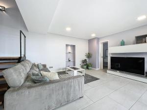 een woonkamer met een grote bank en een open haard bij Gertrudes Dream House in Ponta do Sol