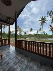 a view from the porch of a resort with palm trees at Nuna Bungalows in Riung