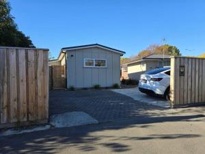 a car parked in a driveway between two fences at Chic Private Studio 5 mins from Airport and shops in Christchurch