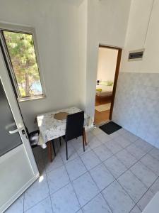 a room with a table and a window and a bathroom at Villa Kralj Mljet in Saplunara