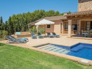 a backyard with a pool and chairs and a house at Villa "Finca de Luxe" mit eigenem Schwimmbad in Campos