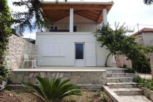 a white house with a porch and stairs at Bungevilia Apartment in Gruda