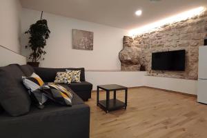 a living room with a couch and a flat screen tv at Bungevilia Apartment in Gruda