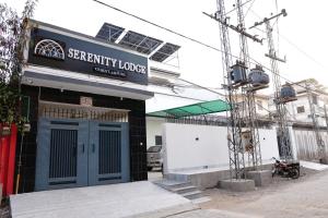 a building with a blue door and a sign on it at Serenity Lodge Guest House in Kalar Goth