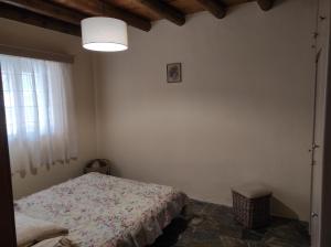a bedroom with a bed and a light and a window at Villa Velanidia in Vitálion