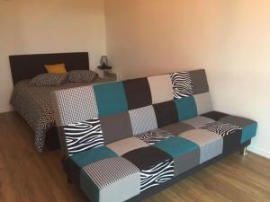 ein Bett und ein Sofa in einem Zimmer in der Unterkunft Beau studio appart meublé à La Suze Dispo septembre 2025 in La Suze-sur-Sarthe