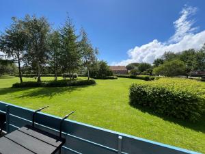 un parco con una panchina di legno su una recinzione di Nyrenoveret lejlighed med balkon og parkering a Esbjerg
