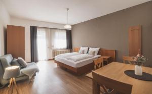 a hotel room with a bed and a table at Residence Chiavi D'Oro - Goldener Schl&uuml;ssel in Bressanone