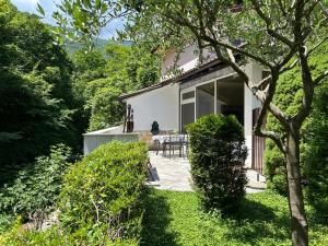 a white house with a patio in the yard at Haus Karin in Lovran