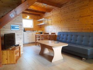 a living room with a blue couch and a table at Chłopy Domki u Jacola in Chłopy