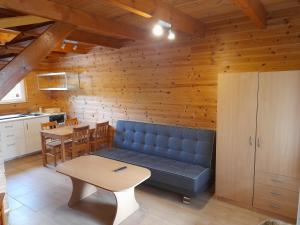 a living room with a blue couch and a table at Chłopy Domki u Jacola in Chłopy
