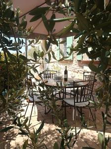 a table and chairs under an umbrella in a patio at Wohnung in Landhaus mit Resort-Adults only in Ottiglio