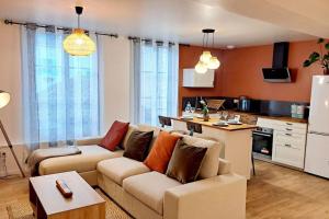ein Wohnzimmer mit Sofa und eine Küche in der Unterkunft Coup de Cœur D'Auxerre in Auxerre
