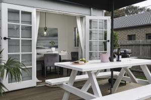 Un patio con una mesa blanca y un comedor. en She Sells Seashells, en Rosebud