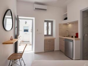 a kitchen with a chair and a sink and a mirror at M&M Parikia's Old Town Studio in Parikia