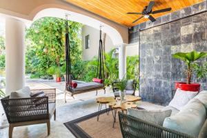 Una sala de estar al aire libre con sofá y sillas. en CASA YOLO - Luxury 4 BR Comfort, Elegance at the paradise in Playacar!, en Playa del Carmen