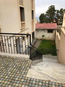a building with a gate and a yard with a house at Location vacance drissou in Aguemoun Taïda